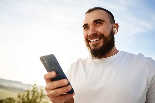 Homem com celular sorrindo Homem com celular sorrindo